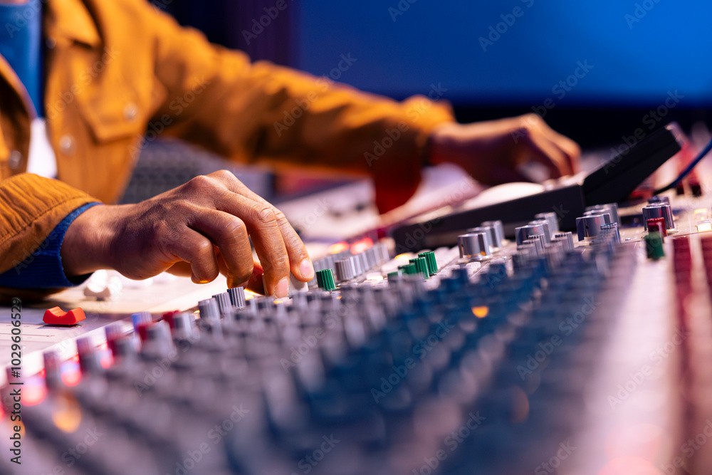 Fototapete african american sound designer twisting knobs to edit songs in studio, operating control board desk
