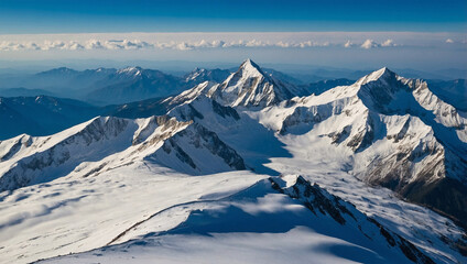 Snow-covered mountain peaks under a clear blue sky, with soft clouds drifting over the summits.