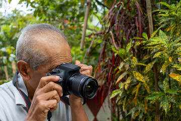 Fototapeta premium Senior nature photographer on mountain - professional photographer taking photos of nature in the forest