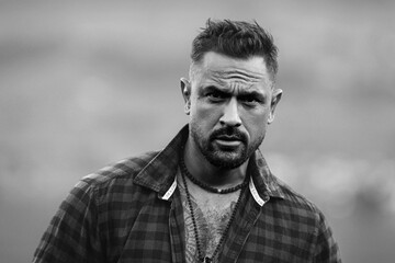 Portrait of the serious handsome man. A Hipster guy model headshot. Male serious face. Handsome serious man. Confident serious male model. Man looking proud. Closeup face of man outdoor. Elegant guy.