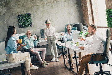 Full length photo of teamwork startup partners pause coffee break comfortable nice creative startup office loft room interior