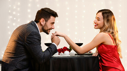 Gallant Man Kissing Hand Of His Pleased Girfriend On Romantic Date In Restaurant