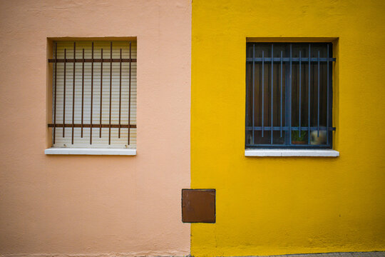 Pared de casa colorida con dos ventanas que parecen una cara