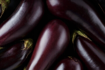Fresh Ripe Eggplants Arranged on Dark Background, Vegetable Harvest Concept, Top View