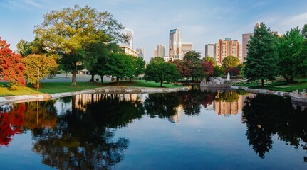 Pond in Marshall Park and downtown city skyline of skyscrapers at sunrise. Charlotte, North Carolina, United States.