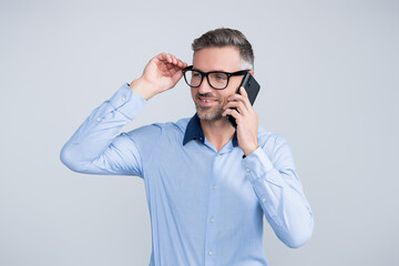 Man phone conversation in glasses. Mature businessman with phone. Business communication. Business man having phone call isolated on grey. Businessman using phone. Telephone interview