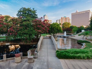 Pond in Marshall Park and downtown city skyline of skyscrapers at sunrise. Charlotte, North...