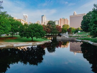 Pond in Marshall Park and downtown city skyline of skyscrapers at sunrise. Charlotte, North Carolina, United States.