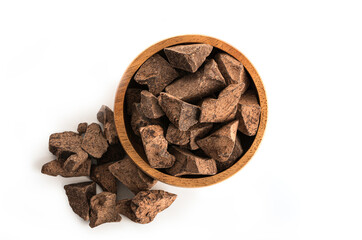 Cocoa mass in wooden bowl isolated on white background. Top view