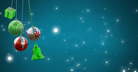 Naklejka premium Image of christmas baubles over light spots on blue background