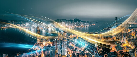 A nighttime aerial view of Hong Kong, China, with streaks of light representing the city's energy and connection. © YiuCheung