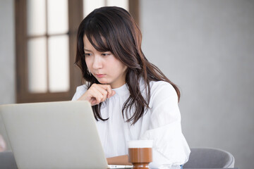 Profile of a troubled young woman thinking while looking at a computer.　
