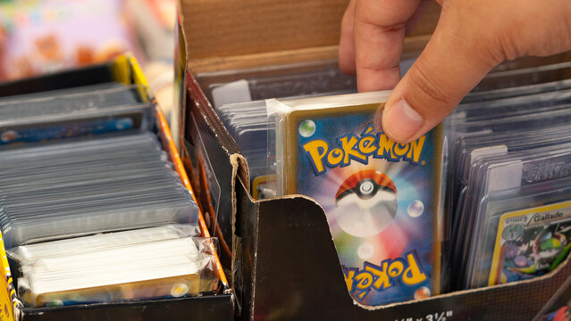 Budokan Geek Convention In GUAYAQUIL, ECUADOR - 
OCT 13, 2024 - A person browsing through a collection of Pok&eacute;mon trading cards in protective sleeves at a geek convention. Collectible card  game.