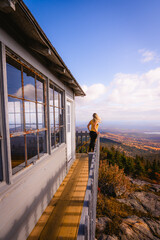 Wind Sweeps Hair Female Hiker Yellow Shirt Looks Out Over Fire Tower in New England. Kearsarge Fire Tower New Hampshire Fall Foliage Autumn Season