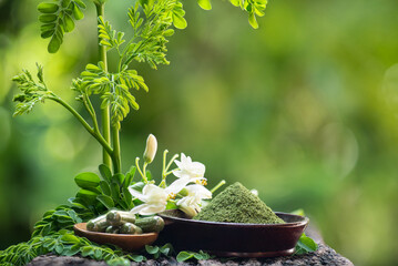 Moringa oleifera or Moringa  fresh leaves, powder,flower and powder in capsule on natural  background.