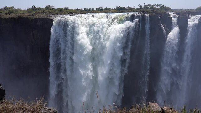 Victoria Falls is a waterfall on the Zambezi River, located on the border between Zambia and Zimbabwe. It is one of the largest waterfalls in the world