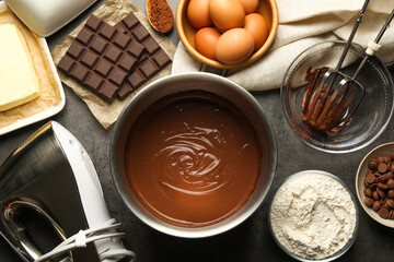 Chocolate dough in bowl and ingredients on grey table, flat lay