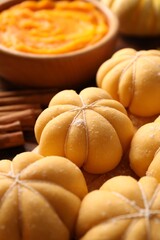 Raw pumpkin shaped buns and ingredients on table, closeup