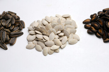 Roasted pumpkin seeds, sunflower seeds and watermelon seeds on white background.