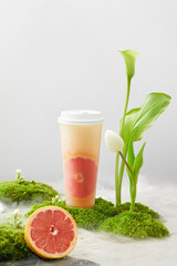 Grapefruit drink in a plastic cup, photography scene in water, no logo packaging