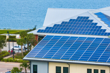 Fototapeta premium Florida office building with solar roof. Blue photovoltaic panels for producing clean ecological electric energy. Investing in renewable electricity concept