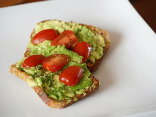 Delicious smashed avocado on toast on a white plate