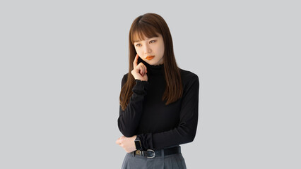 考えごとをする若い女性・ビジネスウーマン
