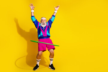 Full size photo of funky sporty man exercise hula hoop empty space vintage sportswear isolated on yellow color background © deagreez