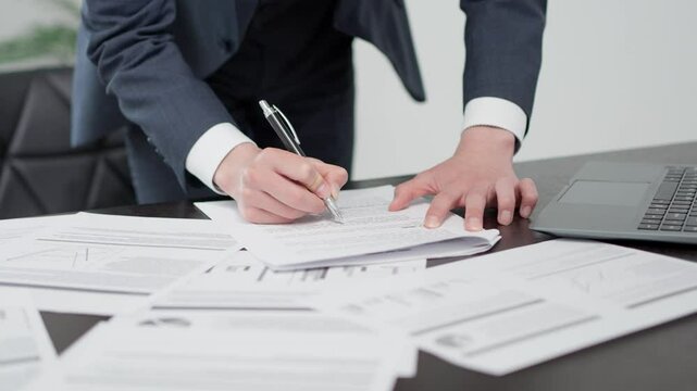 急いで資料を確認するビジネスマンの手元