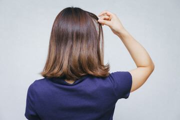 髪の毛の痛みを気にする女性
A woman concerned about hair damage