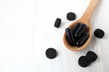 Activated charcoal tablets in a spoon, top view.