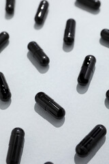 Activated carbon in the form of tablets, on a light background.