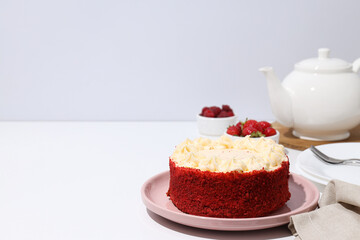 Red velvet cake on pink plate, towel, teapot and berries on white background, space for text