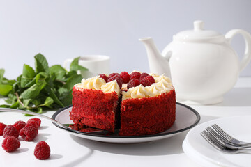 Red velvet cake, teapot, mint and berries on white background