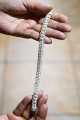 Goldsmith is showing a beautiful handmade silver bracelet