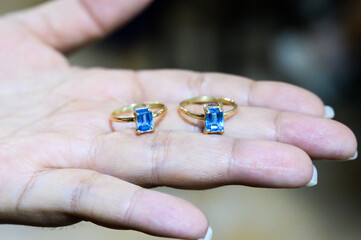 Goldsmith is showing two gold rings with blue topaz stones