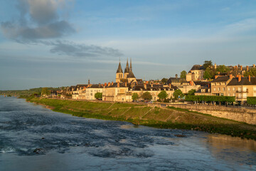View of the Loire River embankment with the St. Nicholas Church in the ancient city of Blois on a sunny summer day, Blois, Loir-et-Cher, France