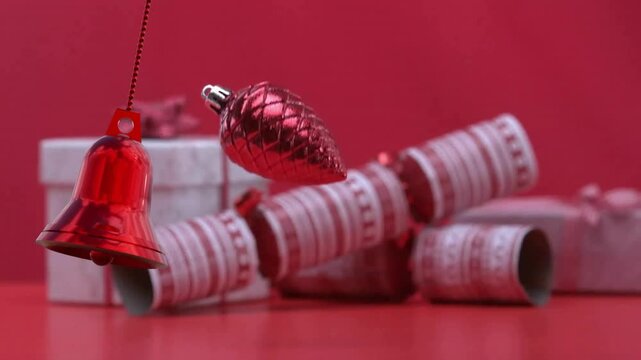 Animation of christmas baubles over christmas cracker and git on red background