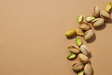 Pistachios in a plate, on a beige background.