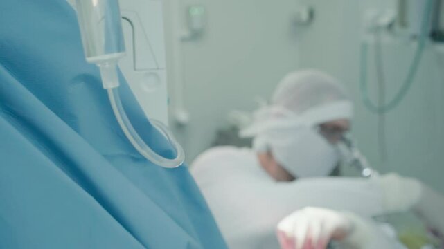 Doctor operates with assistant aid. I.V. against surgeon performing artery bypass surgery supported by nursing staff in hospital operating room