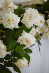 A bouquet of white roses and daisies. The roses are the main focus of the image, with their white petals and green stems. The daisies are smaller and more spread out