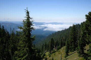 View of Cascade Mountain Range wreathed in clouds from a high vantage point on Mt Hood, with a...