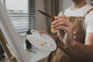 an artist is sitting in his own painting studio with his various painting tools, which is canvas,...