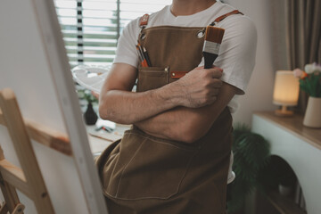 a painter is in his painting studio, a rising male artist is focusing on creating his best paintings, both in drawing and painting, palette, canvas, paintbrush, oils, watercolors, poster colors.