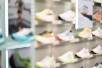 Abstract Blur Background of Row of shoes on display in shop. A view of a wall of shoes inside the store. Modern new stylish sneakers running shoes.