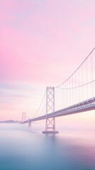 Fototapeta premium A bridge spans a body of water with a pink sky in the background. The bridge is a suspension bridge with a white and gray color scheme
