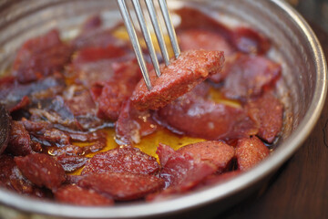  a dish of turkish breakfast sausage in a pan on a wooden table