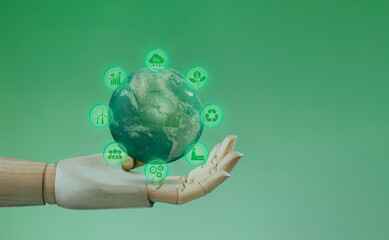Isolated wooden hand holding globe on green background. Concept of circular sustainable...