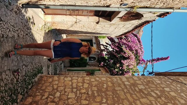 Supetar Town on Brac Island Near Split, Croatia. Beautiful Harbor With White Boats, Palm Trees, Houses and Church Tower. Tourists Walking the Street on Sunny Day