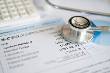 Plan for medical expenses concept. Medical treatment expense on bill statement with calculator and stethoscope.